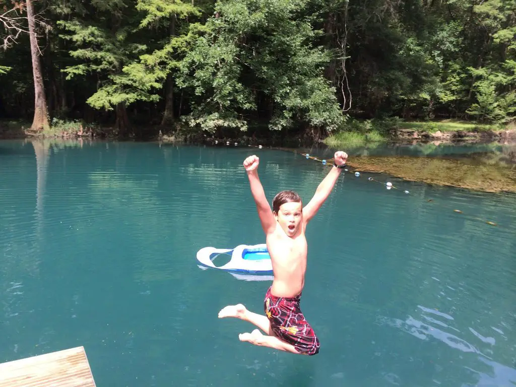 Silas Highland of RV Wanderlust jumping off the dock at Florida Caverns State Park